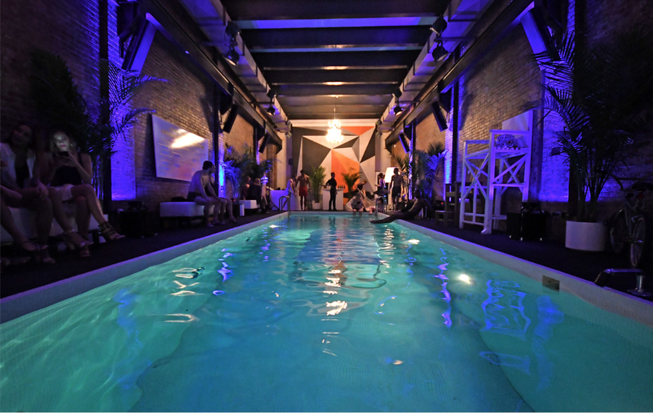 Elegant venue with illuminated pool and dramatic blue purple event lighting by CitiView AV production team